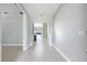 A hallway leading to an open kitchen and living area with neutral paint and tile floors at 113 Azure Mist Way, Daytona Beach, FL 32124