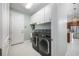 Laundry room with overhead cabinets, utility sink, and stainless-steel washer and dryer at 113 Azure Mist Way, Daytona Beach, FL 32124