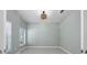 An empty room with neutral paint, white trim, a modern light fixture, and a window at 113 Azure Mist Way, Daytona Beach, FL 32124