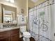 Cozy bathroom with decorative shower curtain, vanity, and warm tones at 1144 Legg Dr, Apopka, FL 32712