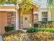 Charming front door with decorative wreath, sidelights, and stone pillar accents at 1144 Legg Dr, Apopka, FL 32712