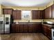 Well-lit kitchen with stainless steel refrigerator, dark cabinets, and spacious countertops at 1144 Legg Dr, Apopka, FL 32712