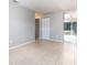 Spacious living room featuring neutral paint, tile flooring, and sliding glass door at 124 Lake Villa Way, Kissimmee, FL 34743