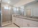 Bathroom featuring dual granite vanity, and glass enclosed walk-in shower at 1260 Tupelo Trl, Haines City, FL 33844