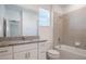 Bathroom featuring a granite countertop, large mirror, and tub shower combo at 1260 Tupelo Trl, Haines City, FL 33844