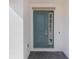 Inviting front door with side window, set in a white wall with gray pavers at 1260 Tupelo Trl, Haines City, FL 33844