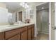 Bright bathroom with double sinks, vanity, and a walk-in shower with glass enclosure at 1494 Moon Valley Dr, Davenport, FL 33896