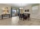 Well-lit dining room with tan tile floors, modern lighting, and access to the outdoor patio at 1494 Moon Valley Dr, Davenport, FL 33896