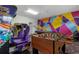 Vibrant game room with arcade games, foosball table, pool table, and colorful geometric wall design at 1494 Moon Valley Dr, Davenport, FL 33896
