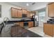 Kitchen with granite countertops, tile floors, wood cabinets, and stainless steel appliances at 1494 Moon Valley Dr, Davenport, FL 33896