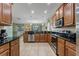 Open kitchen with wood cabinets, stainless steel appliances, granite countertops, and tile floors at 1494 Moon Valley Dr, Davenport, FL 33896