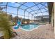 Screened-in pool and spa with a safety fence and basketball hoop on the pool deck at 1494 Moon Valley Dr, Davenport, FL 33896