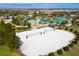 Aerial view of a pristine sand volleyball court and community pool with lush tropical landscaping at 1494 Moon Valley Dr, Davenport, FL 33896