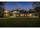Night view of elegant brick home featuring a covered walkway and lush lawn at 1501 Lake Markham Rd, Sanford, FL 32771