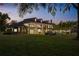 Stately brick home with a covered veranda and inviting outdoor lighting at twilight at 1501 Lake Markham Rd, Sanford, FL 32771
