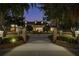 Beautiful estate home featuring brick entrance with landscaped garden, water feature, and manicured grounds in the evening light at 1501 Lake Markham Rd, Sanford, FL 32771