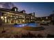 Twilight view of a backyard oasis with pool, spa, and well-lit landscaping with a brick mansion in the background at 1501 Lake Markham Rd, Sanford, FL 32771