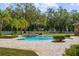 Inviting pool with fountains, surrounded by brick pavers and lush landscaping, creating a serene backyard oasis at 1501 Lake Markham Rd, Sanford, FL 32771