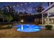 Beautiful pool area at dusk with lights illuminating the water and landscaping, creating a magical ambiance at 1501 Lake Markham Rd, Sanford, FL 32771