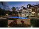 Stunning brick home featuring a beautiful pool and spa area with lush landscaping and string lights at 1501 Lake Markham Rd, Sanford, FL 32771