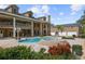 Aerial view of a stunning pool and spa area surrounded by brick pavers, lush greenery, and a grand home at 1501 Lake Markham Rd, Sanford, FL 32771