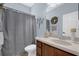 Bathroom boasts a vanity, framed mirror, decorative wreath, and a shower with gray curtain at 1843 Van Allen Loop, Auburndale, FL 33823