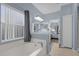 Bright bathroom with tub, neutral tile, and door opening to main bedroom at 1843 Van Allen Loop, Auburndale, FL 33823