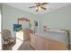 Bedroom features neutral paint, ceiling fan, wood furniture, and a bed with gray bedding at 1843 Van Allen Loop, Auburndale, FL 33823