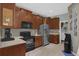 This kitchen features sleek black appliances, wooden cabinets, and tiled floors at 1843 Van Allen Loop, Auburndale, FL 33823
