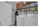 Laundry room showcases a washer, dryer, shelves, and a storage area for convenience at 1843 Van Allen Loop, Auburndale, FL 33823