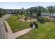 Community playground with play equipment, benches and landscaping in a residential neighborhood by a lake at 1843 Van Allen Loop, Auburndale, FL 33823