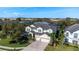 Aerial view of a spacious home with a brick driveway, three-car garage, and lush landscaping at 1910 Lake Roberts Landing Dr, Winter Garden, FL 34787