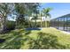 Well-maintained backyard with lush green grass, mature trees, and a trampoline, perfect for outdoor activities at 1910 Lake Roberts Landing Dr, Winter Garden, FL 34787
