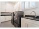 Laundry room with a sink, dark granite counters, and full-size washer and dryer at 1910 Lake Roberts Landing Dr, Winter Garden, FL 34787