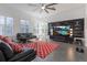 Open living room with large windows, ceiling fan, tile floors, and entertainment center at 1910 Lake Roberts Landing Dr, Winter Garden, FL 34787