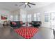 Open living room with large windows, ceiling fan, tile floors, and modern furniture at 1910 Lake Roberts Landing Dr, Winter Garden, FL 34787
