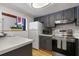 Efficient kitchen with gray cabinets, stainless steel appliances, and a pass-through window for easy serving and natural light at 200 Maitland Ave # 96, Altamonte Springs, FL 32701