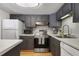 Well-lit kitchen features sleek gray cabinetry, white countertops, and stainless steel appliances for a modern cooking experience at 200 Maitland Ave # 96, Altamonte Springs, FL 32701