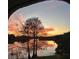 Scenic lake view at sunset with colorful sky reflecting in the water, seen through an archway at 200 Maitland Ave # 96, Altamonte Springs, FL 32701