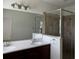 Bathroom featuring dual sinks, a large mirror, and a glass-enclosed shower, creating a spa-like atmosphere at 2205 W Lobelia Dr, Lake Mary, FL 32746