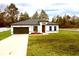 Charming single-story home featuring a large front yard, a modern front door, and an attached garage at 2409 Sw 170Th Pl, Ocala, FL 34473