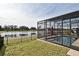 Home's screened-in pool with a lake view, an umbrella stand, and manicured landscaping at 2659 Magpie Way, Sanford, FL 32773