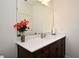 Well-lit bathroom featuring a large mirror, granite countertop, and dark wood cabinets providing style and functionality at 2659 Magpie Way, Sanford, FL 32773