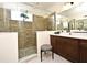 Bathroom with a frameless shower, brown vanity, and white quartz countertops at 2659 Magpie Way, Sanford, FL 32773