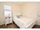 Well-lit bedroom with wood floors, a white bed frame, and a window with plantation shutters at 2659 Magpie Way, Sanford, FL 32773