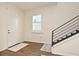 Bright foyer with a window, stylish wood floors, and an elegant staircase with a black banister at 2659 Magpie Way, Sanford, FL 32773