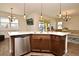 Modern kitchen with stainless steel dishwasher, dark cabinets, and pendant lighting above the island at 2659 Magpie Way, Sanford, FL 32773