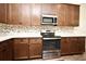 Kitchen showcasing stainless steel oven, dark cabinets, and granite countertops at 2659 Magpie Way, Sanford, FL 32773