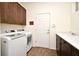 Functional laundry room with a large sink, washer, dryer and wood-look flooring, offering convenience and storage at 2659 Magpie Way, Sanford, FL 32773