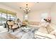Bright living room featuring a cozy sofa, decorative rug, and elegant chandelier at 2659 Magpie Way, Sanford, FL 32773